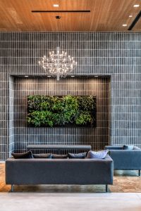 chic lobby with dark paneling, greenery, and chandelier